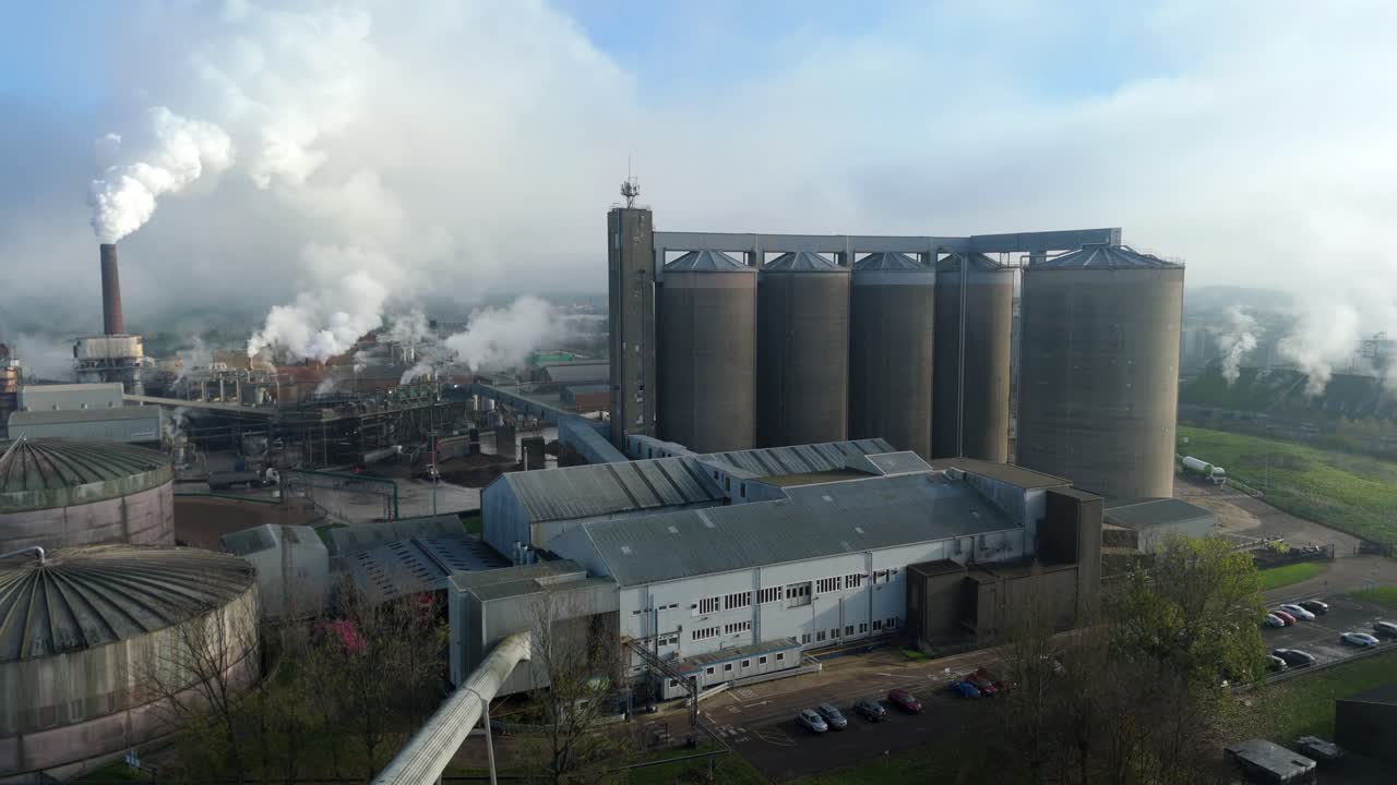 Aerial drone view of Bury St Edmunds sugar factory with huge silos and smoking chimneys during winter campaign in Suffolk United Kingdom