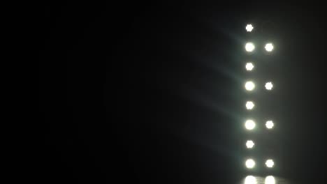 la luz de los reflectores golpea a través de la oscuridad en el escenario