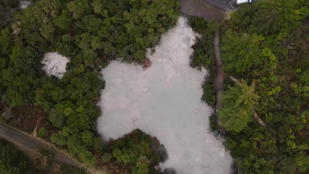 la explosión de la piscina de barro caliente en el país de las maravillas térmicas de wai-o-tapu, rotorua, nueva zelanda - órbita aérea