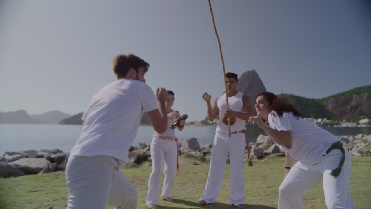 Dynamic Capoeira Training Session by the Water with Rio de Janeiro Landscape