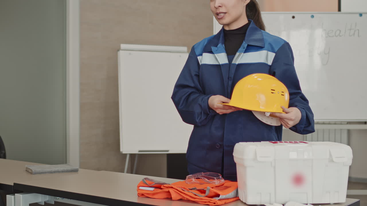 Woman In Coverall Talking Of Hard Hats Usage At Factory