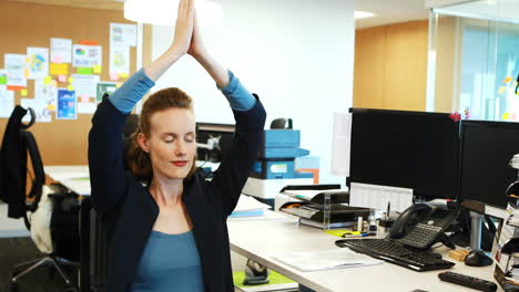 mujer de negocios meditando en la oficina