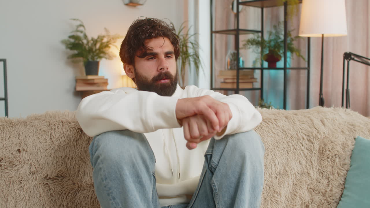 un joven indio triste y frustrado sentado en casa parece pensativo pensando en los problemas de la vida solitaria