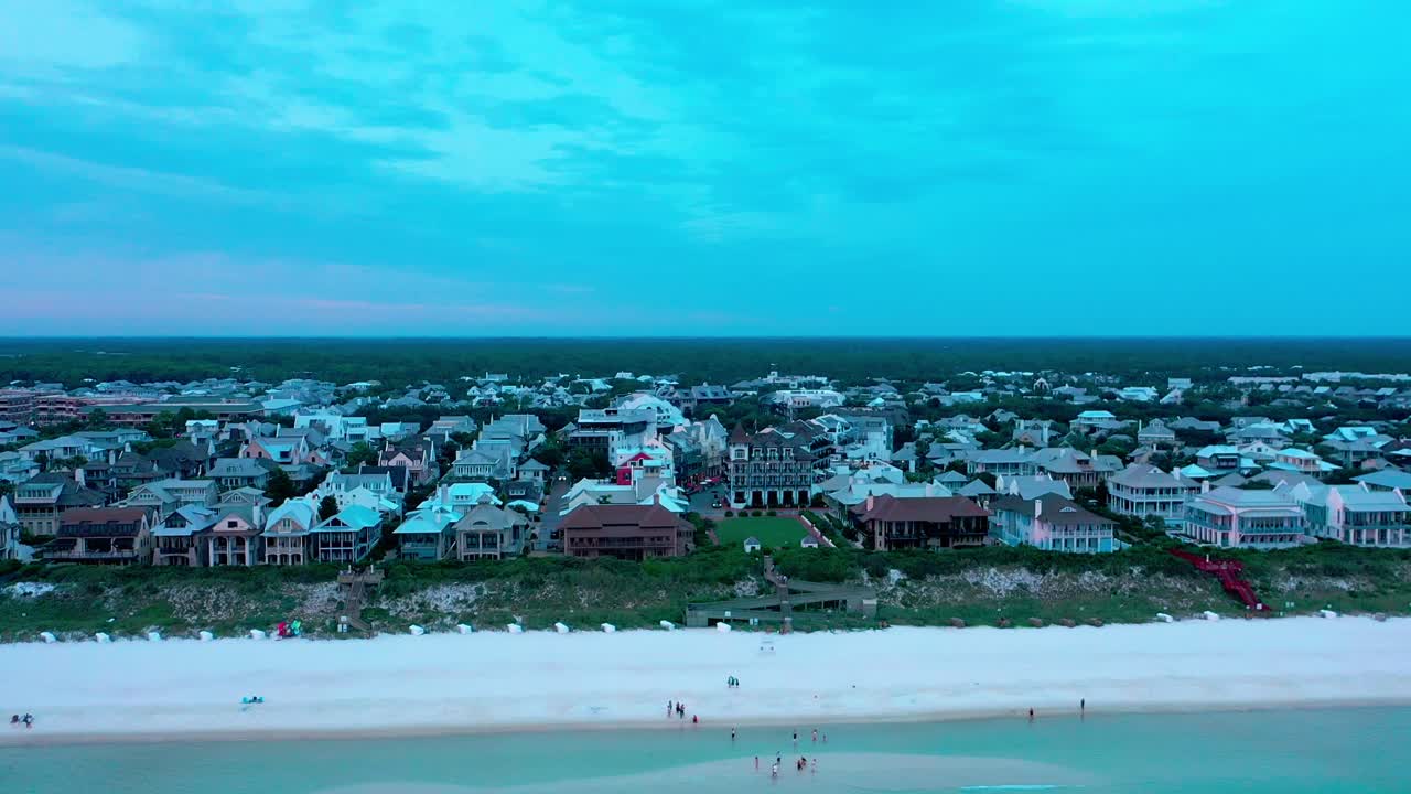 구름이 많은 골든아워 일몰 동안 로즈마리 플로리다의 해변을 바라보며 멕시코 만 위로 드론 뷰 상승 샷