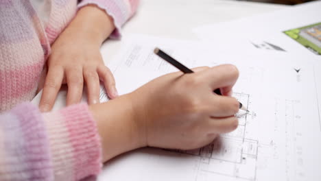 architect at the construction site checks house plan documents with a pencil to check structural design, correctness, and construction strength