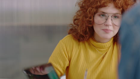 young business people brainstorming beautiful redhead woman using laptop computer sharing ideas showing friend ideas on screen enjoying teamwork in trendy office