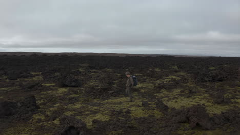 hiker in a volcanic lava field in iceland