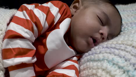 cute 2 month old baby asleep on knitted blanket