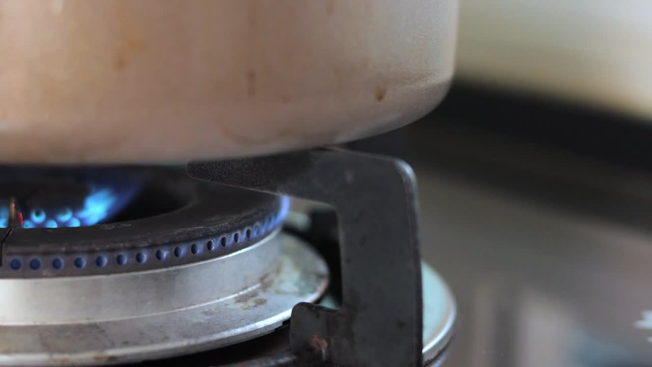 부엌에 있는 스테인리스 냄비에서 요리하기 위해 불을 켜십시오