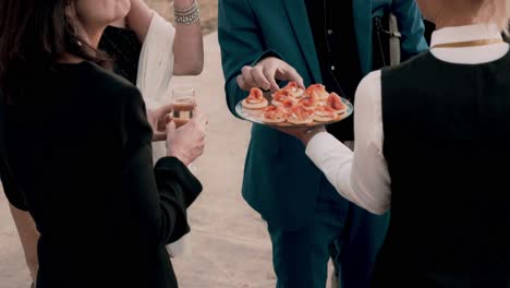 slow motion shot of a waiter serving canapes to guests at a luxury wedding