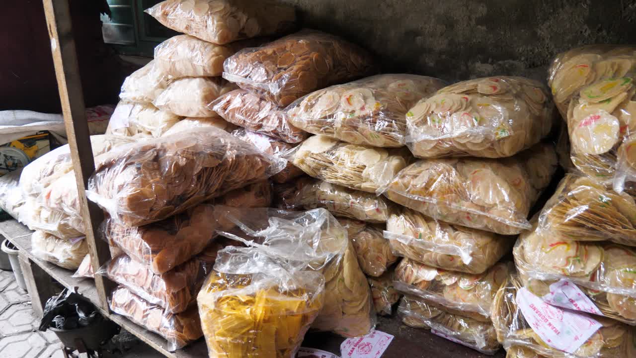 View of plastic bags filled with raw krupuk in Surabaya, Sidoarjo, Indonesia, used for sand production snacks. The scene highlights local food processing and packaging in a traditional setting.