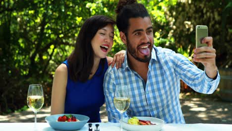 Couple-taking-selfie-with-mobile-phone-in-outdoor-restaurant-4k