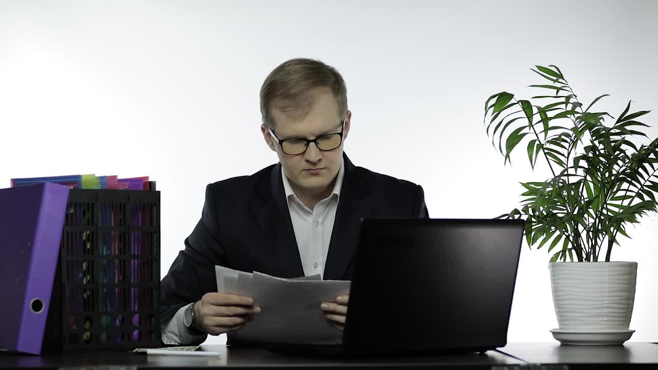 Manager che lavora in ufficio. Legge un rapporto cartaceo scrollando le spalle con dubbio.