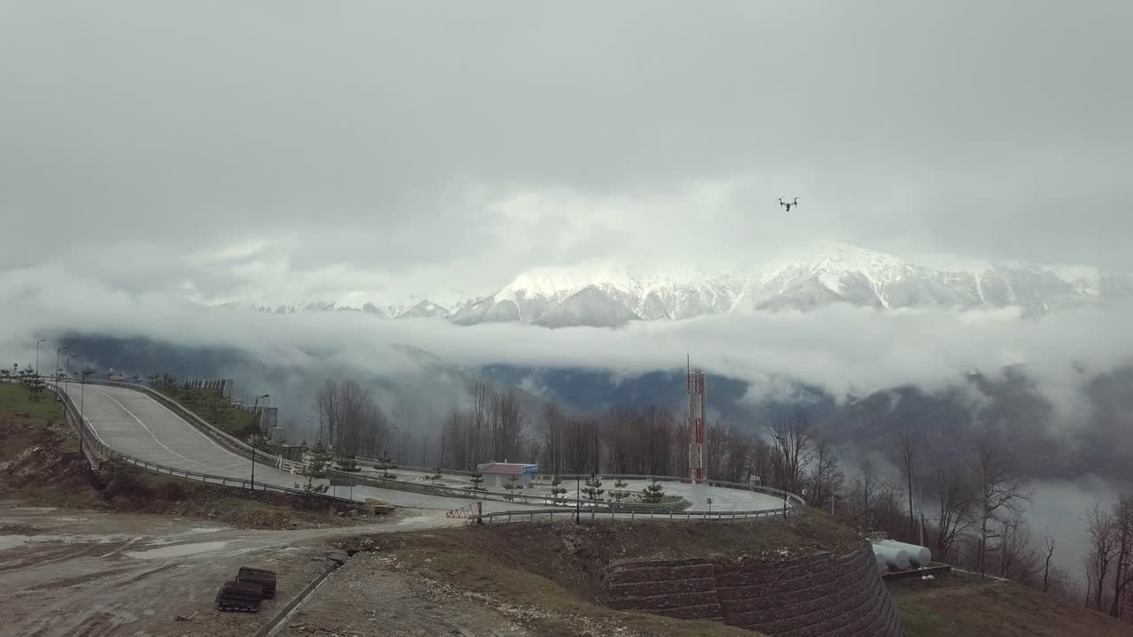 vuelo de avión no tripulado sobre un paso de montaña en tiempo nublado