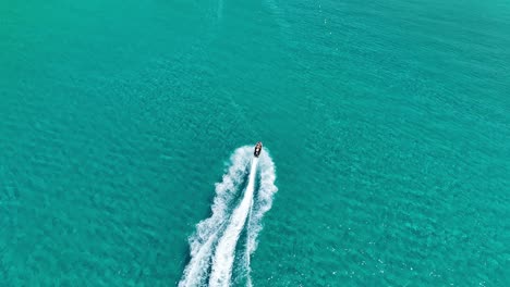 speedboat carving white waves in blue ionian sea waters near corfu island, greece, aerial view