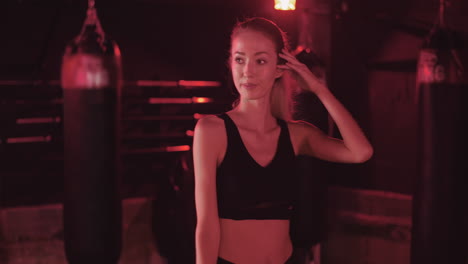 Confident-Young-Woman-Moving-Hand-Through-Long-Hair-At-Health-Club