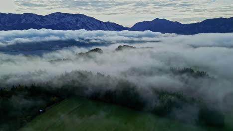 sunrise over misty landscape with the view of mountains in the background, above the clouds and trees in misty landscape with mountains in backdrop, remote jungle scenery, austria