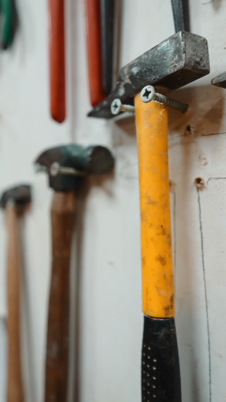 Close Up of Various Hammers and Tools Hanging on a Wall