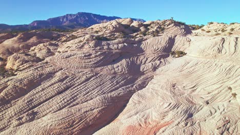 Crane-Tilt-Aerial-View-of-Orange-and-White-Striped-Mountains-in-Yant-Flats,-Utah-near-St