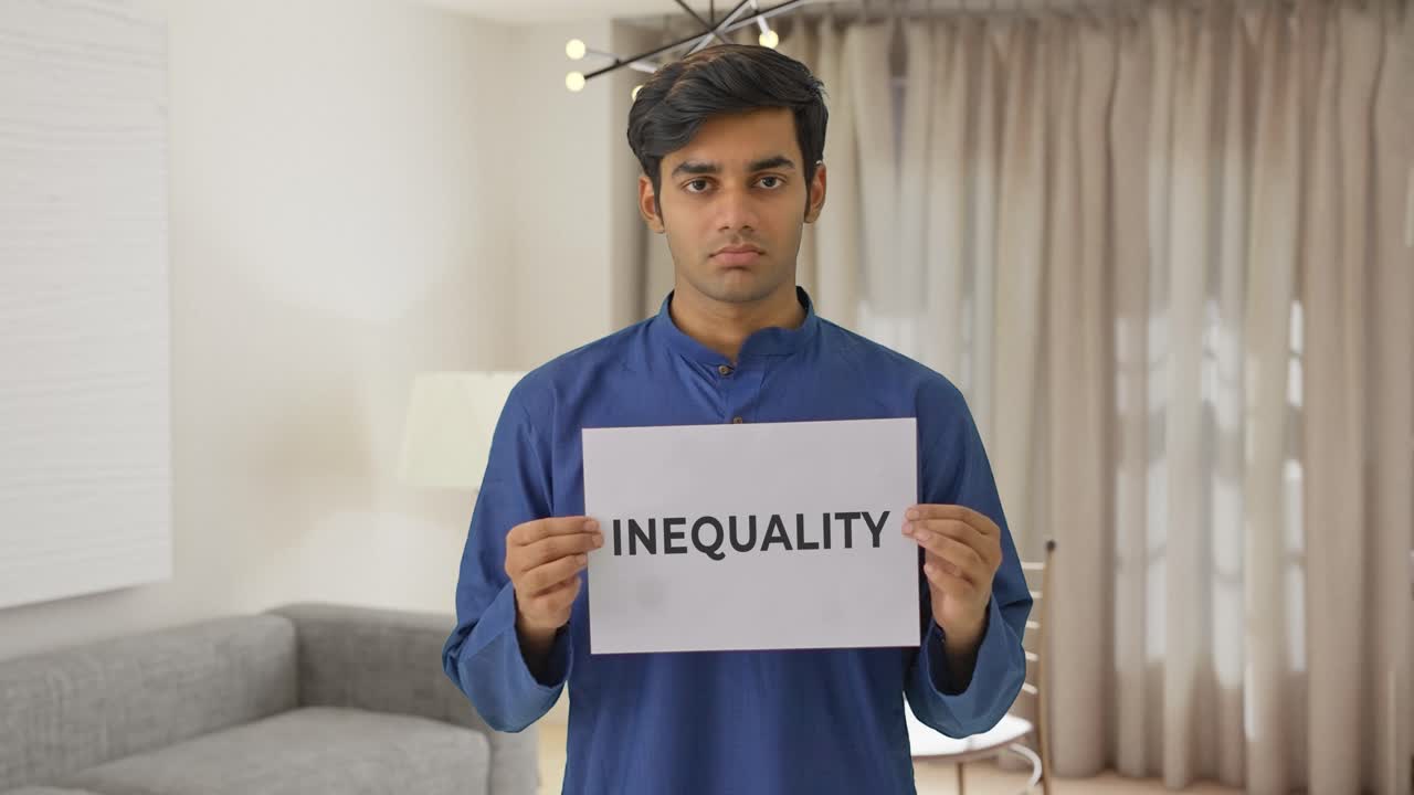 chico indio triste sosteniendo una pancarta de desigualdad