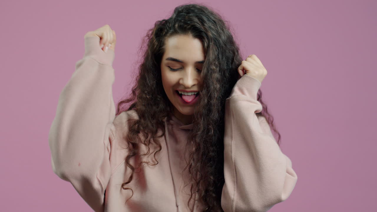 Woman in a Hoodie Smiling and Dancing