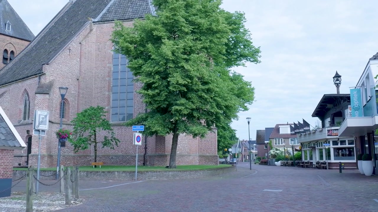 Stille gadescene med historisk murstenskirke i en hollandsk landsby