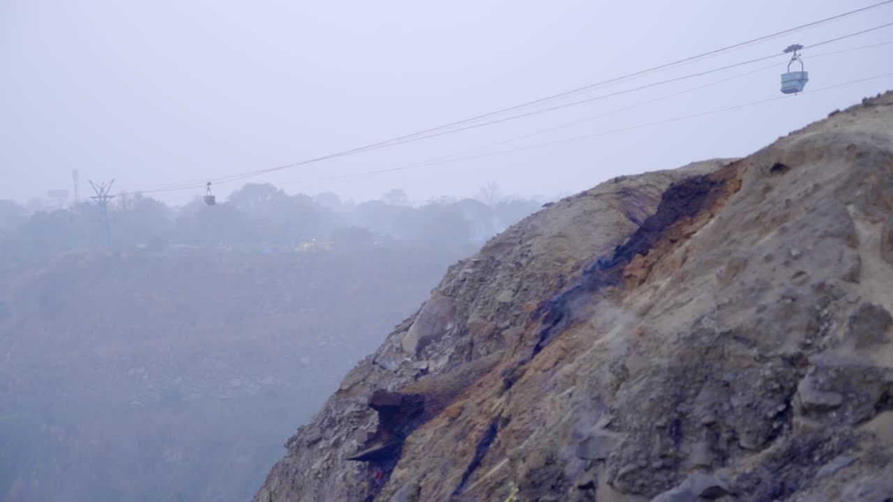 Cable car system traversing a hazy mountain landscape