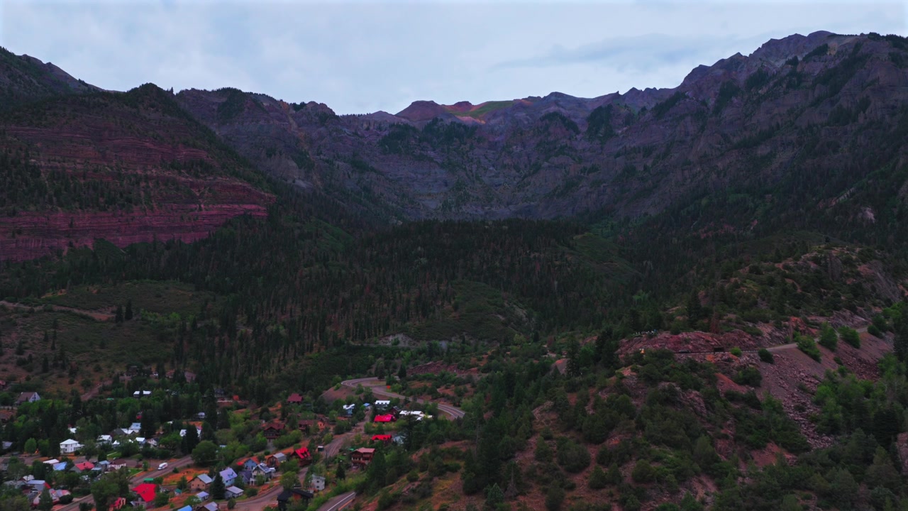 Colorado Ouray'ın tarihi kasabası, Million Dollar Otoyolu, Box Kanyon Şelaleleri manzarası. Amerika'nın küçük İsviçre'si olarak bilinen Kayalık Dağlar'ın öğleden sonra bulutlu gri gökyüzü altında, ileri hareketle çekilmiş havadan drone görüntüsü.