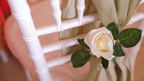 flower decor on a wooden chair at the wedding reception