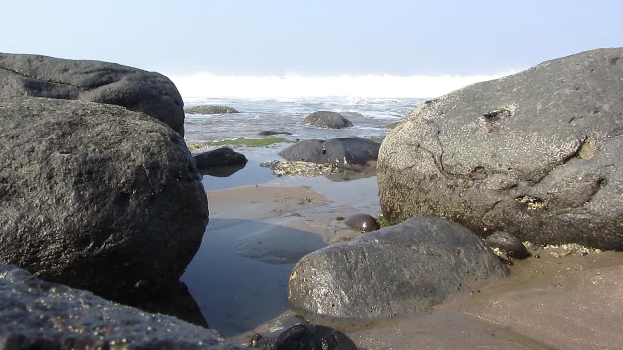 Sea waters flows on the hard rocky beach