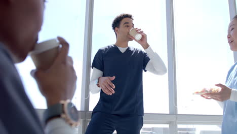 Young-biracial-healthcare-worker-enjoys-a-coffee-break-at-the-hospital