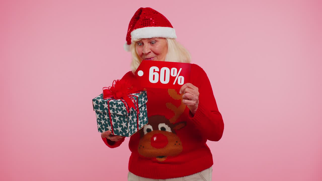 abuela en suéter de navidad mostrando caja de regalos y 60 por ciento de descuento inscripciones texto de pancarta