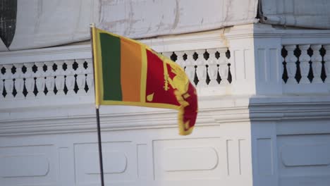 bandiera nazionale dello sri lanka in un'onda polare con la brezza di fronte all'hotel e ristorante del bastione a galle fort illuminazione al tramonto sullo sfondo, rallentatore statico b roll clip