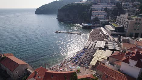 budva, montenegro: aerial of plaža ričardova glava with sunbathers and adriatic sea