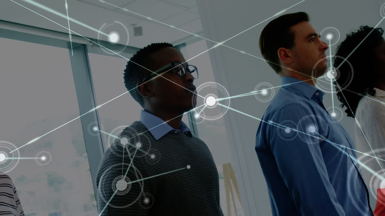 Animation of network of connections over group of diverse office colleagues walking at office