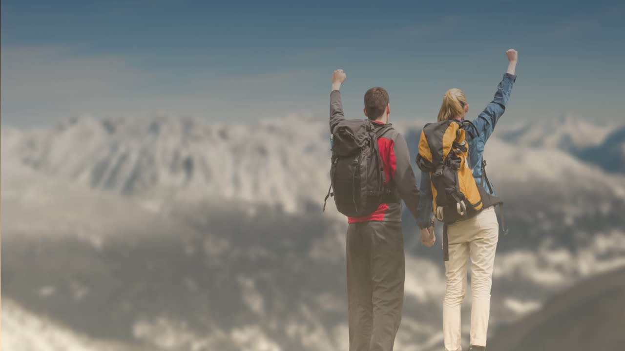 animación de una pareja de excursionistas caucásicos tomados de la mano y levantando las manos en la cima de la montaña
