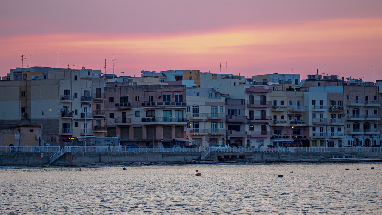 fotografía de los edificios de la ciudad costera de gzira, il-gzira, malta mientras el cielo al atardecer se desvanece al anochecer en timelapse