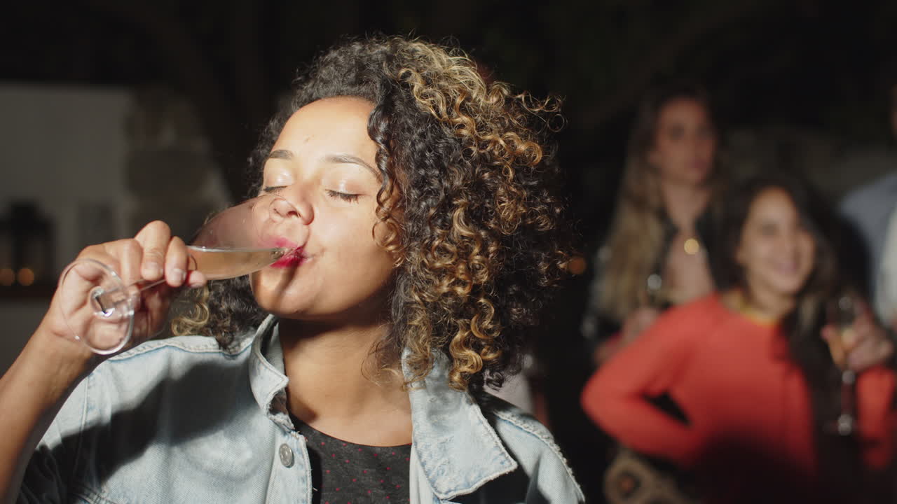 African-American woman drinking alcohol and looking at camera