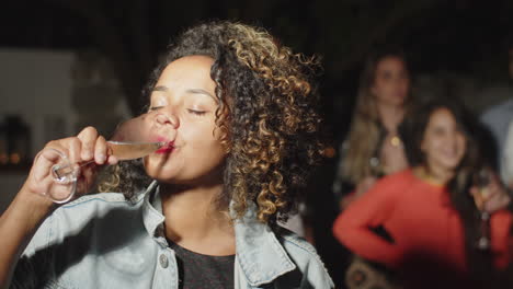 african-american woman drinking alcohol and looking at camera