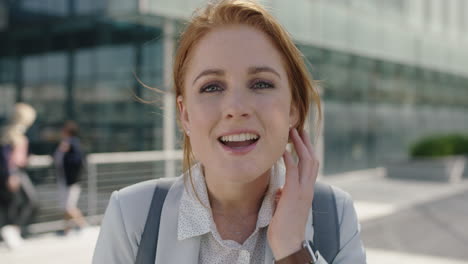 close up portrait of beautiful red head business woman intern smiling friendly running hand through hair enjoying lunch break