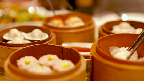 chopsticks pick dim sum from bamboo steamers in a warm, inviting restaurant setting with soft lighting