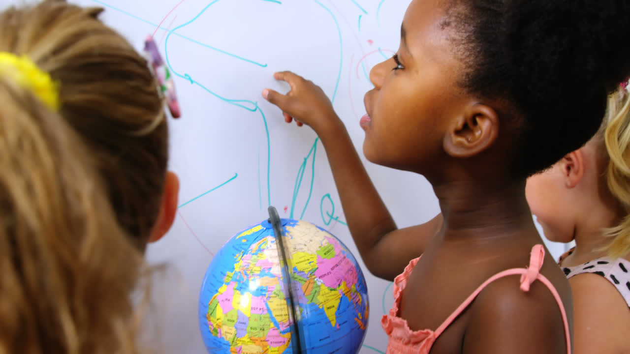 Kids studying globe in classroom