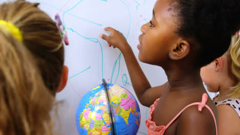 kids studying globe in classroom