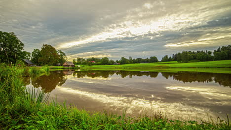 cottage by a pond during a cloudscape sunrise time lapse