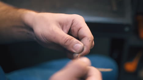 el joyero tuerce el alambre dorado conectado a la pulsera de cerca
