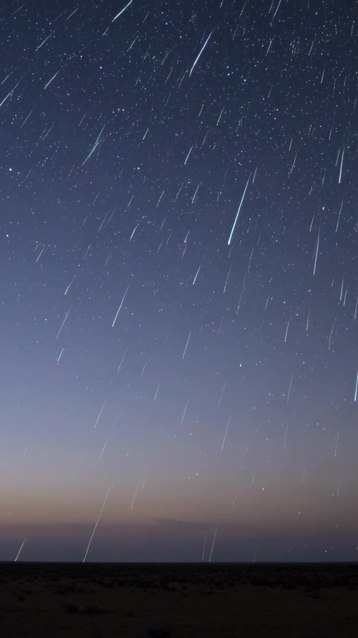 Vertikal video: Strømmende meteorstriper krysser nattehimmelen over lav horisont, meteoroider kommer inn