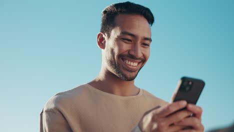 Blauer-Himmel,-Telefon-Und-Junger-Mann,-Der-Einen-Text-Tippt