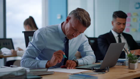 displeased businessman using laptop. male manager working with documents