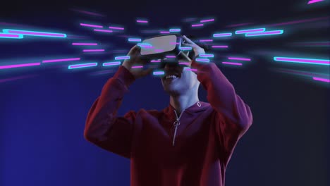 Animation-of-glowing-light-trails-of-data-transfer-and-asian-man-in-vr-headset