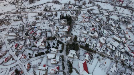 Mountain-village-of-Voskopoja-in-Albania-covered-by-white-snow,-traditional-guesthouses-and-hotels